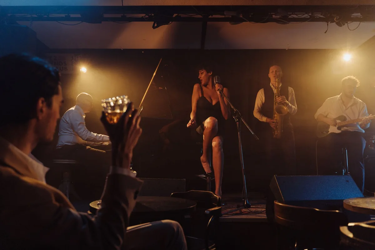 Eine Sängerin und eine Liveband im warmen Bühnenlicht
