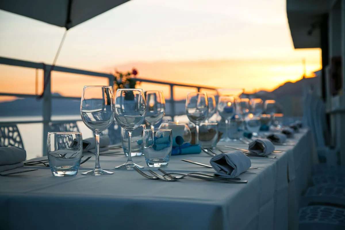 Ein gedeckter Tisch im Freien mit Meerblick bei Sonnenuntergang